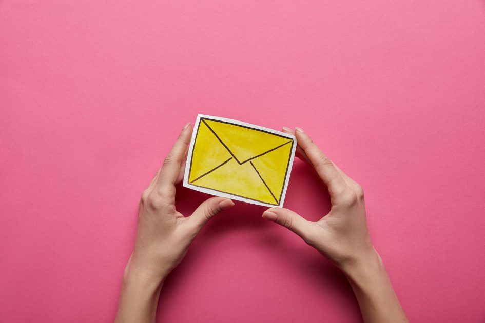top view of yellow email sign on pink background