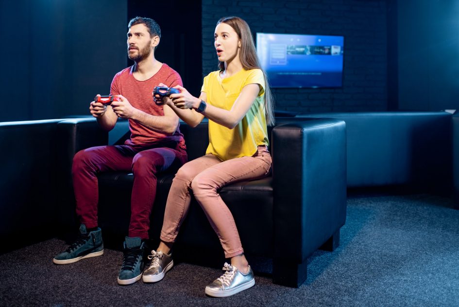 Couple playing video games with gaming console in the club