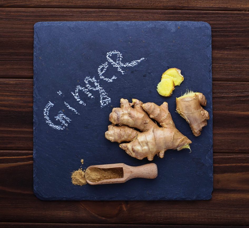 Ginger root and ground ginger on slate