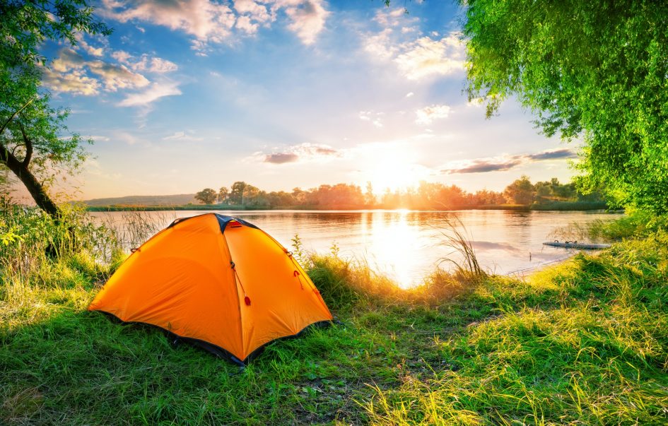 Orange tent on the lake at sunset