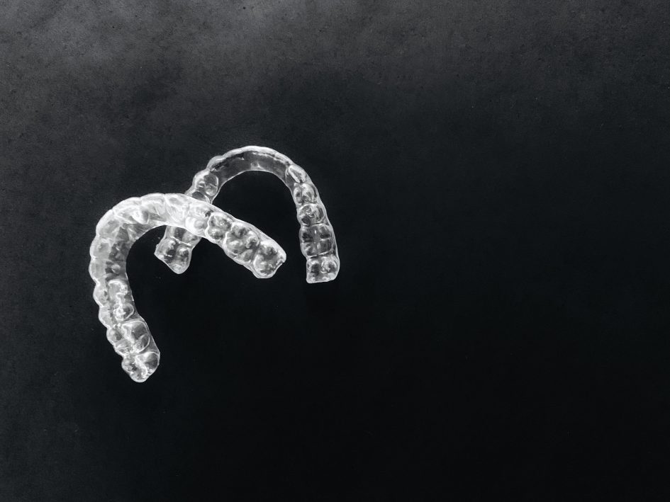 Invisalign retainers on a black background, braces